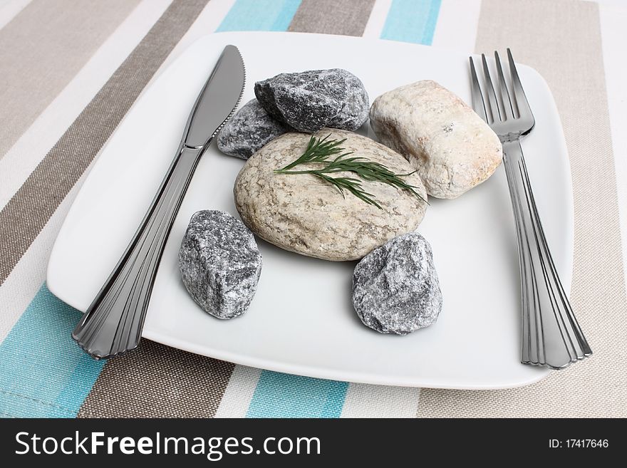 White plate with stones and fork