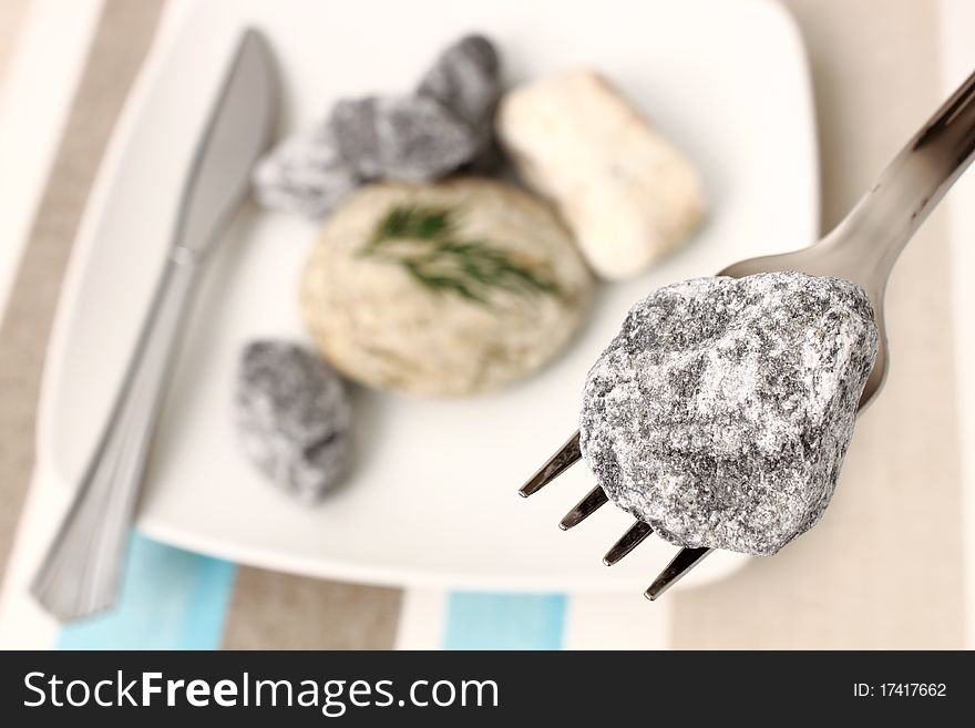 White plate with stones and fork