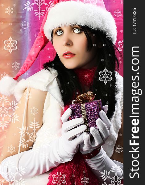 Sexy young woman with christmas elf costume holding gift surrounded by snowflakes. Sexy young woman with christmas elf costume holding gift surrounded by snowflakes.