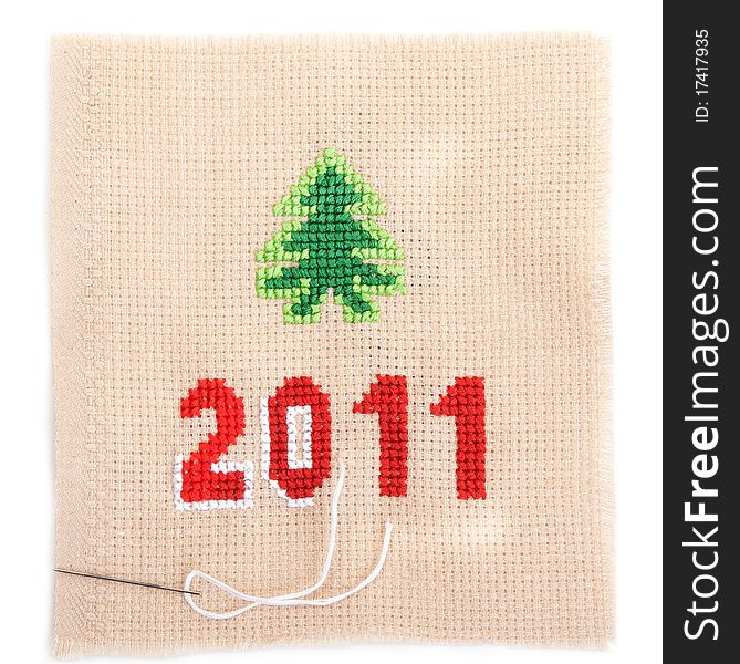 Embroidered spruce and the inscription 2011 on beige fabric