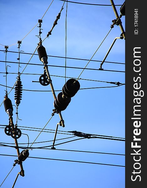 A close up picture of power lines with blue sky in the background