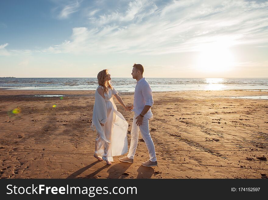 Love, Waiting For The Baby. Couple, Pregnant Woman And Man, In White Flying Clothes, Walk, Hold Hands, Dance.