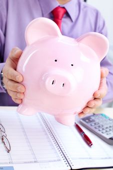 Businessman With A Pig Bank Royalty Free Stock Images