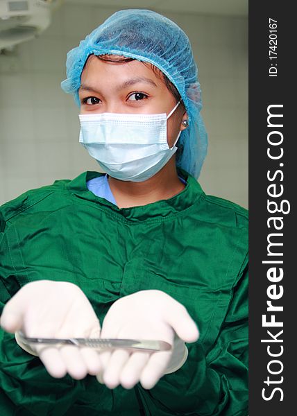 Asian nurse showing a surgical knife. Asian nurse showing a surgical knife