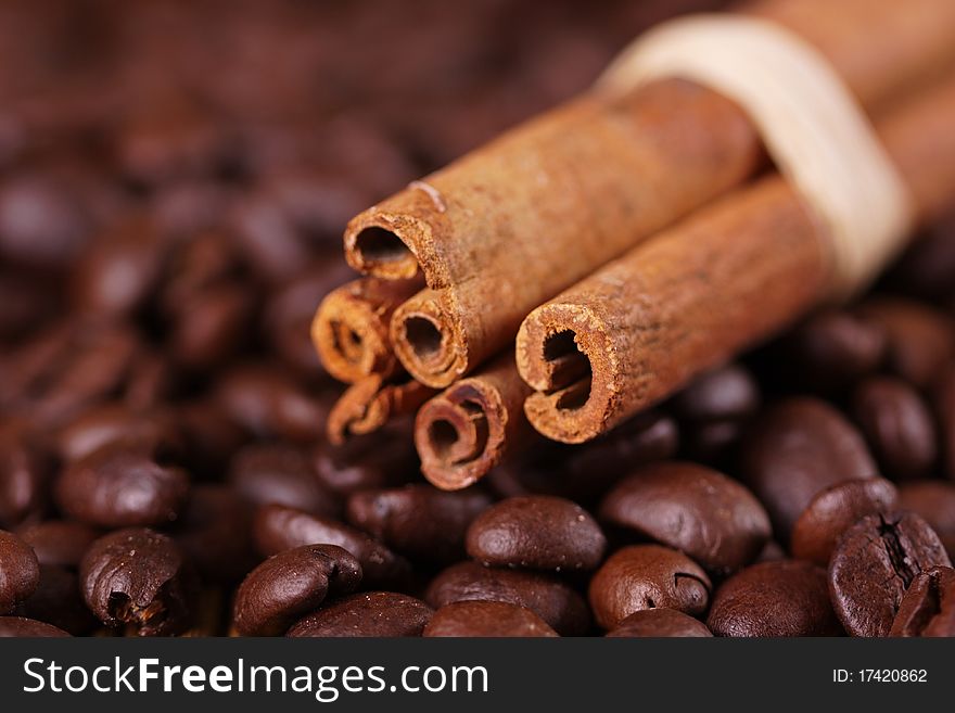 Tasty cinnamon on coffee beans background