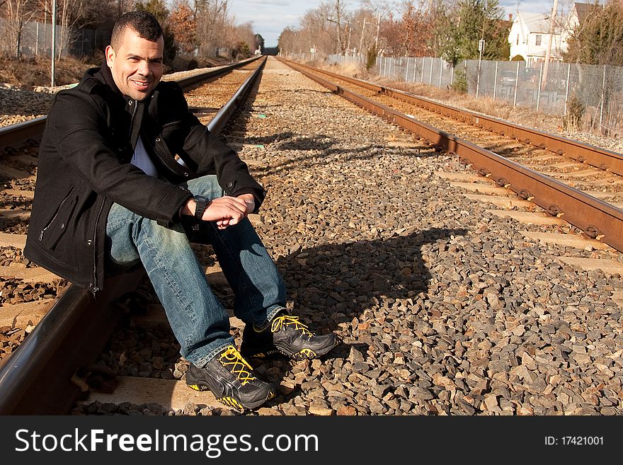 Guy on vacation waiting for his train at the train station.