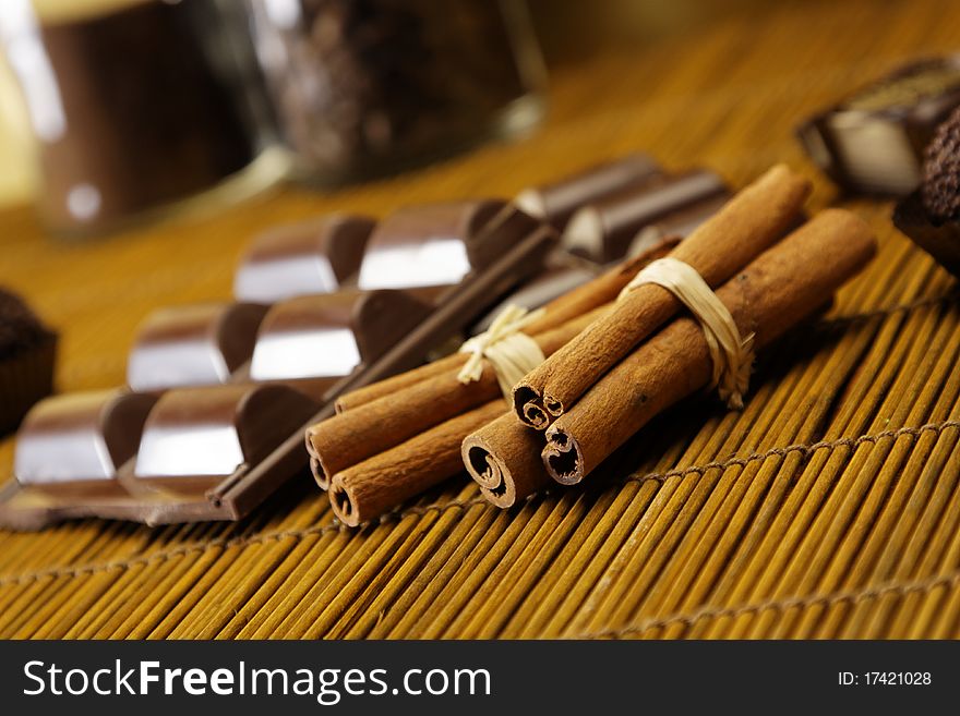 Tasty chocolate with cinnamon on coffee beans background