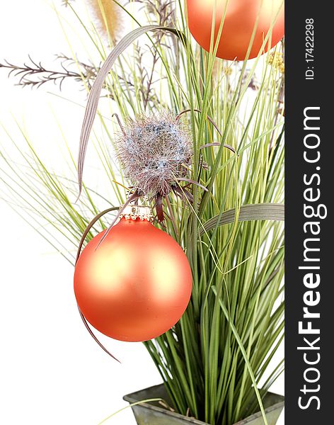 Bunch with artificial grass and blue flowers in metal vase decorated with Christmas orange balls isolated on the white background.Closeup. Bunch with artificial grass and blue flowers in metal vase decorated with Christmas orange balls isolated on the white background.Closeup.