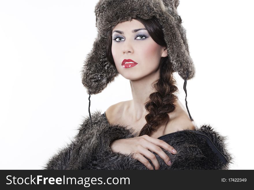 Portrait of young beautiful woman in a fur coat and hat