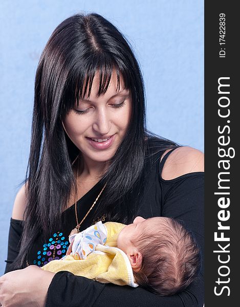 The happy woman shining with happiness holds on hands of the first child. The happy woman shining with happiness holds on hands of the first child.