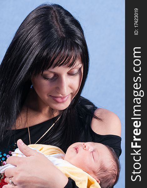 The happy woman shining with happiness holds on hands of the first child. The happy woman shining with happiness holds on hands of the first child.