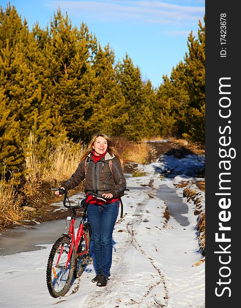 Woman with bicycle goes on forest. Woman with bicycle goes on forest