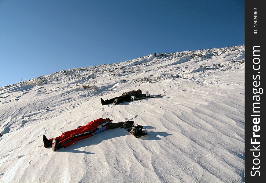 Two persons lie on snow. Two persons lie on snow