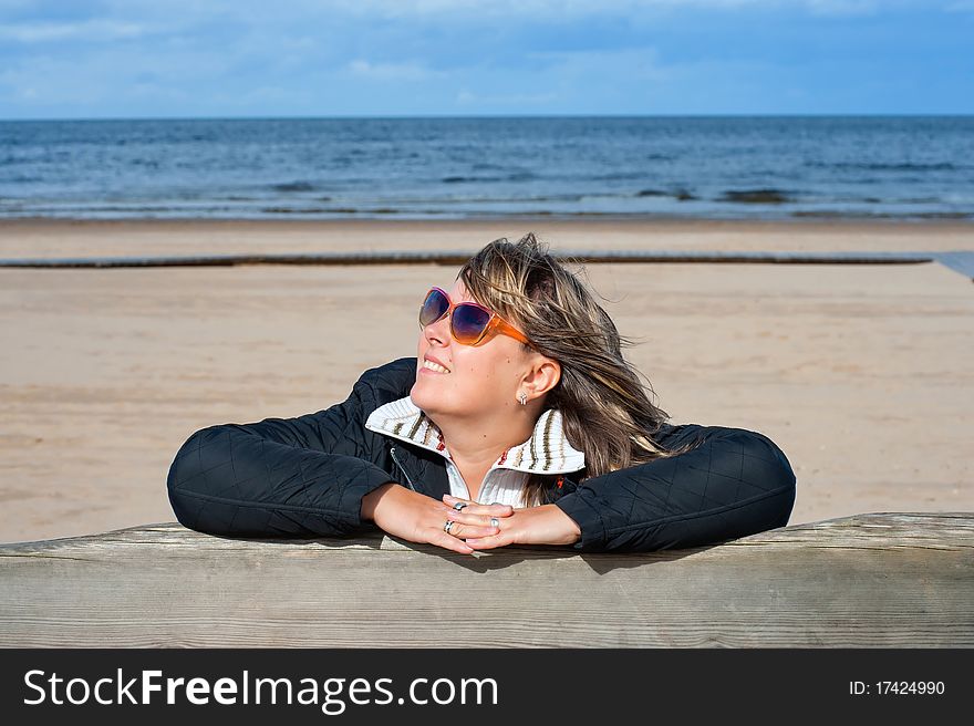 Portrait of mature woman in sunglasses relaxing at the Baltic sea in autumn day. Portrait of mature woman in sunglasses relaxing at the Baltic sea in autumn day.