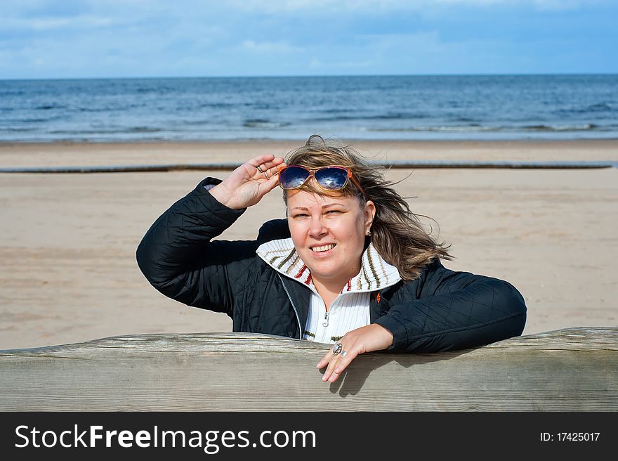 Portrait of mature woman in sunglasses relaxing at the Baltic sea in autumn day. Portrait of mature woman in sunglasses relaxing at the Baltic sea in autumn day.