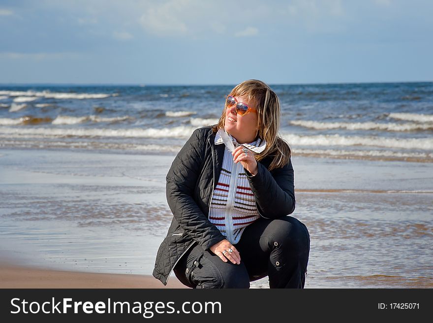 Mature chubby woman relaxing at the Baltic sea in autumn day. Mature chubby woman relaxing at the Baltic sea in autumn day.