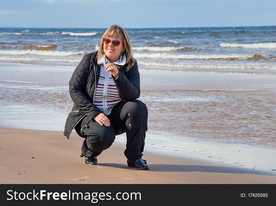 Mature chubby woman relaxing at the Baltic sea in autumn day. Mature chubby woman relaxing at the Baltic sea in autumn day.