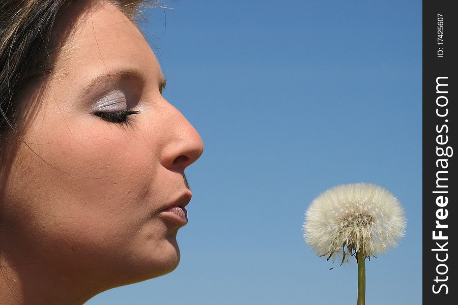 Portrait of a young girl with dandelion outdoor.