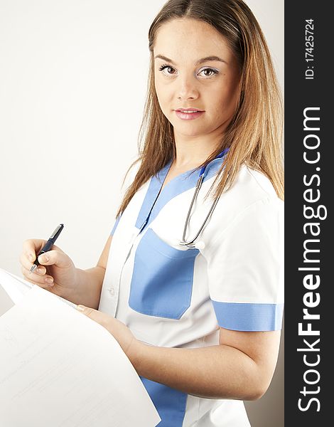 Young woman doctor or nurse holding wearing white and blue scrubs. Young woman doctor or nurse holding wearing white and blue scrubs