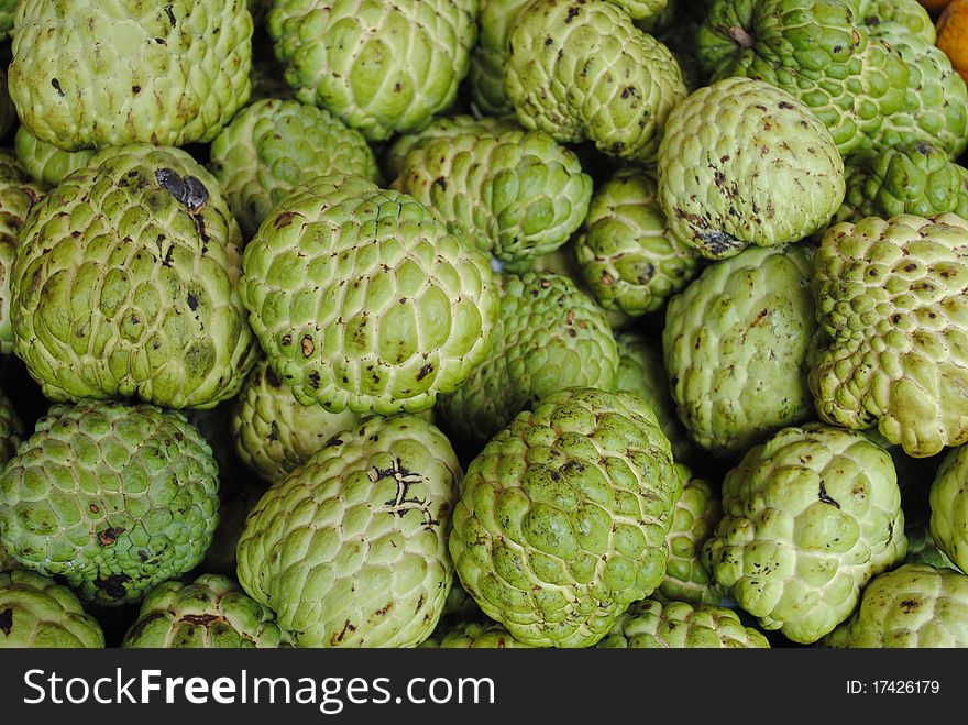 A lot of green custard apple on the table.