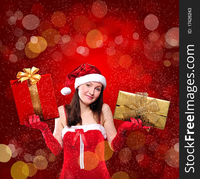 Portrait of a young girl dressed as Santa Claus on a red background. Girl gives gifts. Happy New Year and Merry Christmas!