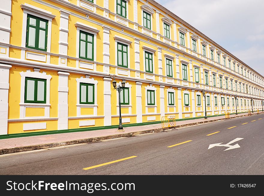 The pattern of the road beside the yellow building