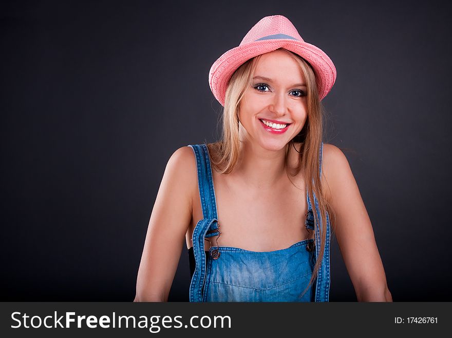 Pretty girl in pink hat and jeans overalls