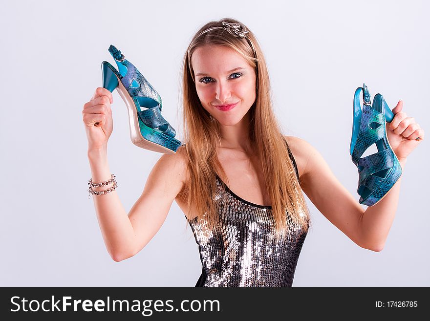 Pretty girl with shoes in hands