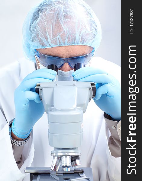 A scientist man working with microscope in laboratory