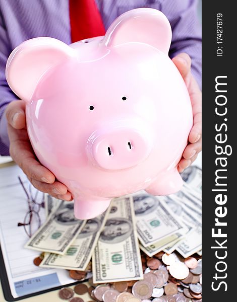 Businessman holding a pink pig bank. Businessman holding a pink pig bank