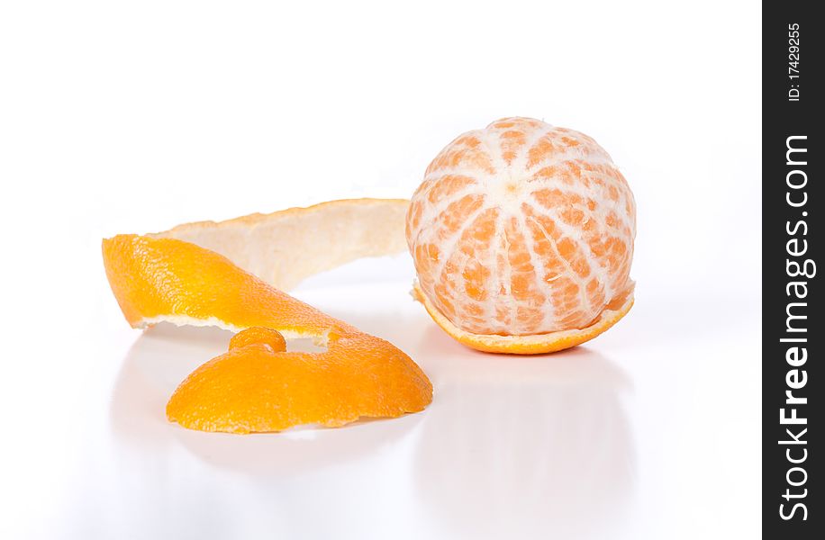 A macro angled front view of a peeled clementine with its peel and shadow on a white background. A macro angled front view of a peeled clementine with its peel and shadow on a white background.
