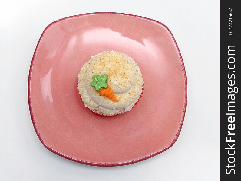 Sweet vanilla cupcake on pink plate on white background. Sweet vanilla cupcake on pink plate on white background