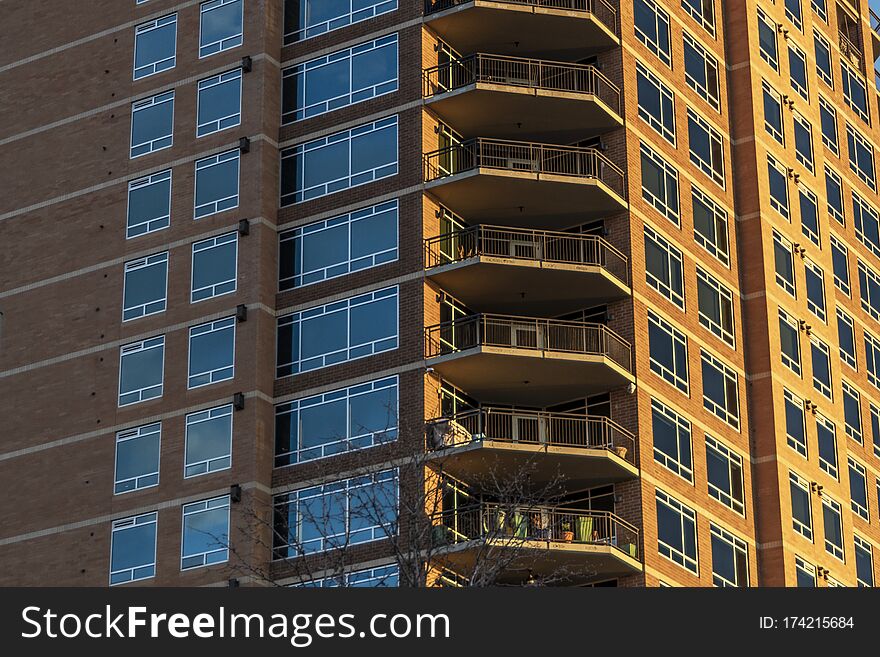 Side lit red brick high rise building with close up of the balconies. Side lit red brick high rise building with close up of the balconies