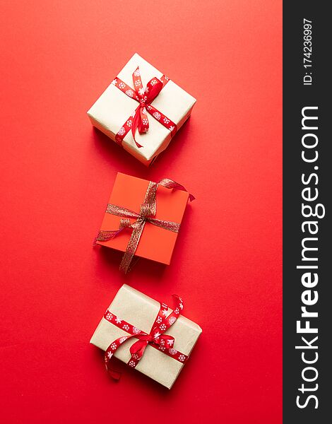 Red And White Craft Paper Gift Boxes On Red Background. Minimal New Year Concept. Noel.