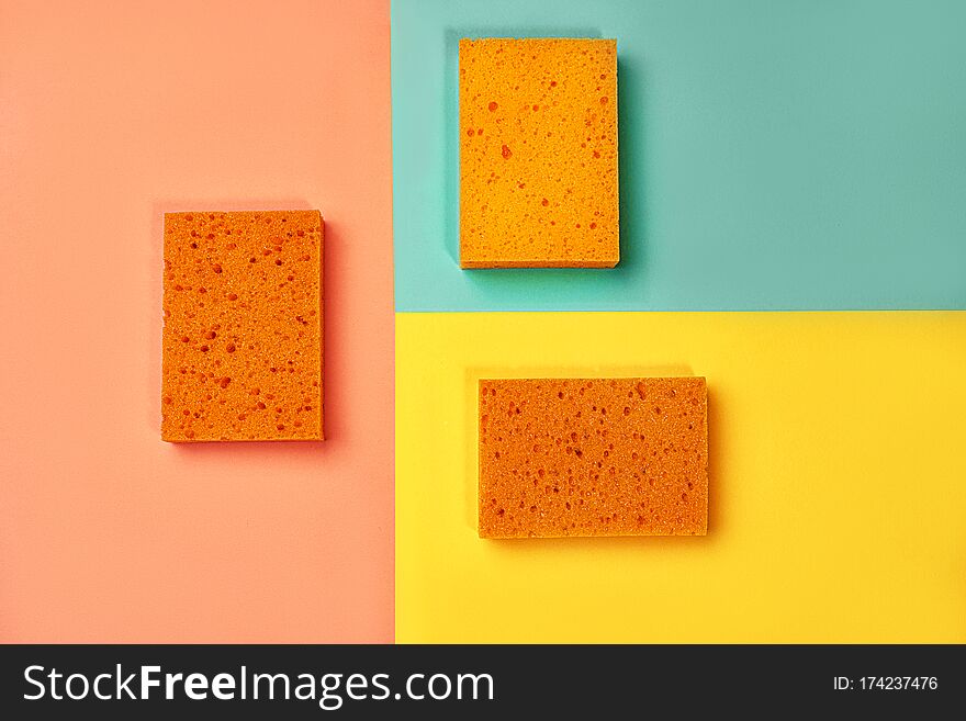 Trendy Collage Made Of Orange Color Sponges On Yellow, Pink Coral And Trendy Mint Green Blue Background.