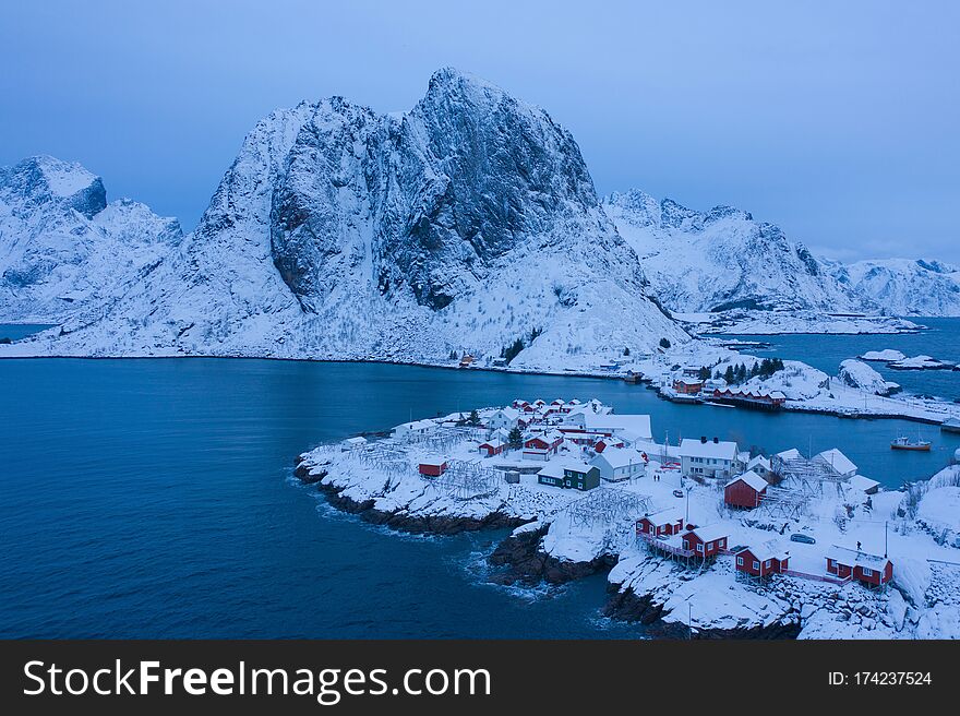 Aerial View Of Norwegian Fishing Village In Reine City, Lofoten Islands, Nordland, Norway, Europe. White Snowy Mountain Hills,