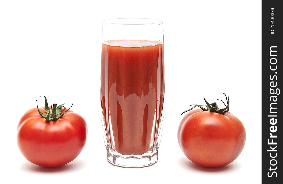 Fresh tomatoes and a glass full of tomato juice on white