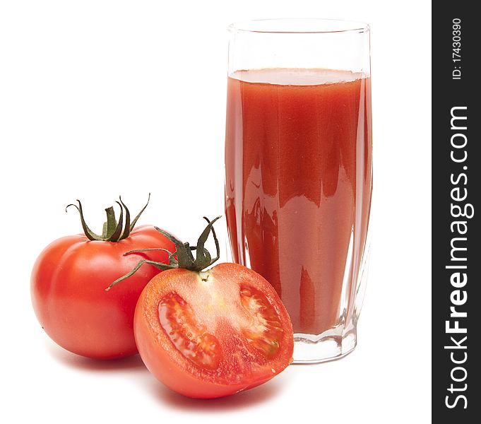 Fresh tomatoes and a glass full of tomato juice on white