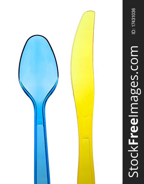 Dark blue plastic spoon and yellow plastic knife. Dark blue plastic spoon and yellow plastic knife