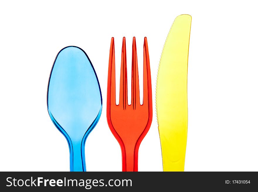 Dark blue plastic spoon, red plastic plug and yellow plastic knife. Dark blue plastic spoon, red plastic plug and yellow plastic knife