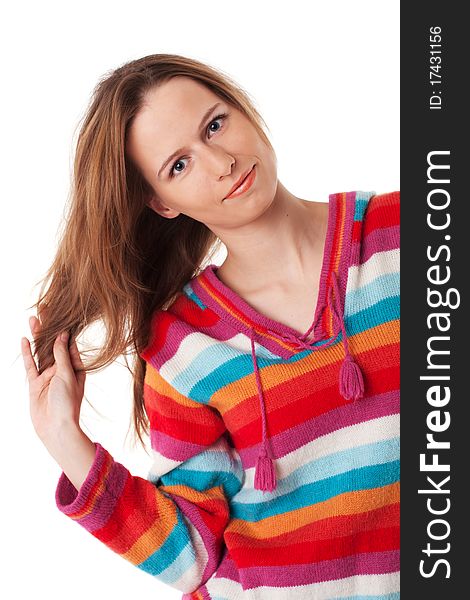 Bright young woman plays with her long hair standing in colorful blouse on white background