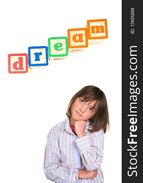 A young girl in a dreaming posture with the word dream above in blocks. A young girl in a dreaming posture with the word dream above in blocks.