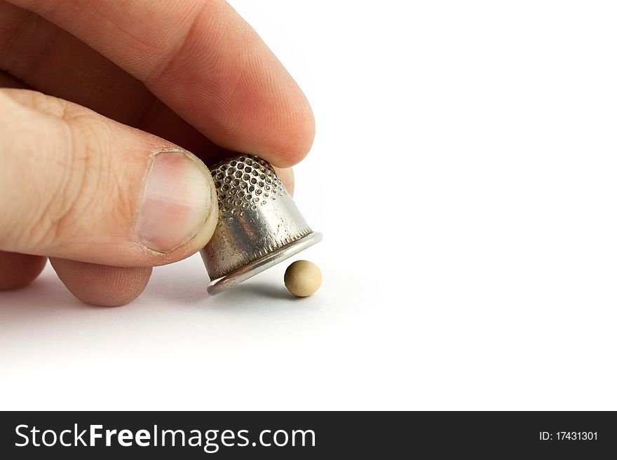 Thimble and pea isolated on white background