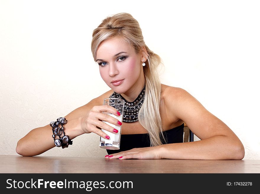 Woman with glass of milk against yellow wall at table