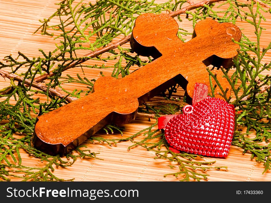 Wooden Orthodox cross, decorative heart and branches of conifers. Wooden Orthodox cross, decorative heart and branches of conifers