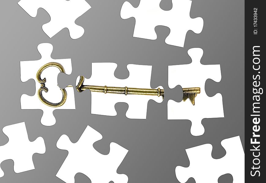 Jigsaw puzzle pieces of a key isolated against a grey background. Jigsaw puzzle pieces of a key isolated against a grey background