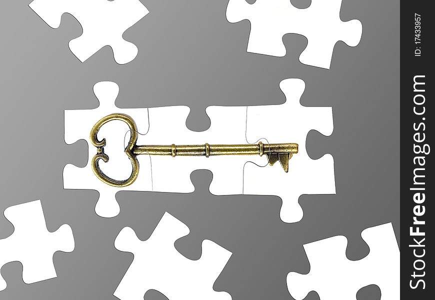 Jigsaw puzzle pieces of a key isolated against a grey background. Jigsaw puzzle pieces of a key isolated against a grey background