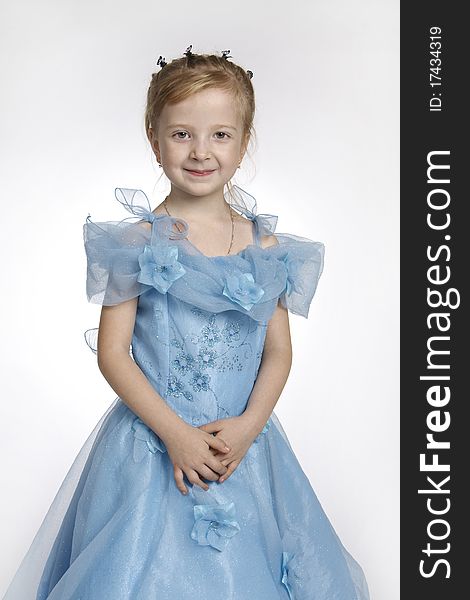 Portrait of the girl of 5 years, in a blue dress on a white background
