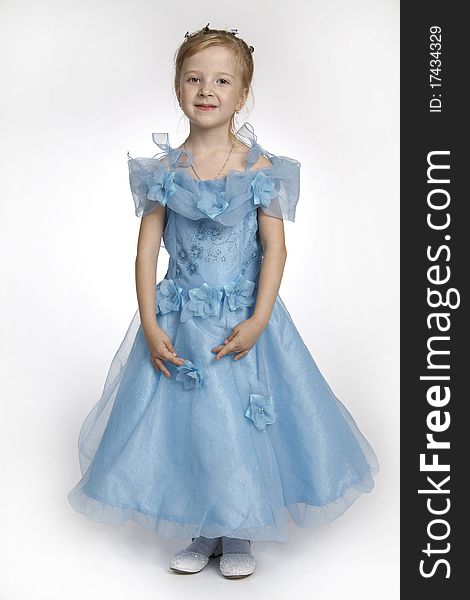 Portrait of the girl of 5 years, in a blue dress on a white background