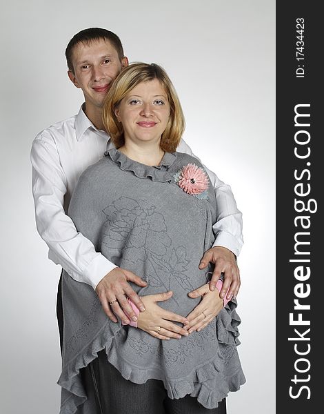 The man embraces the pregnant woman